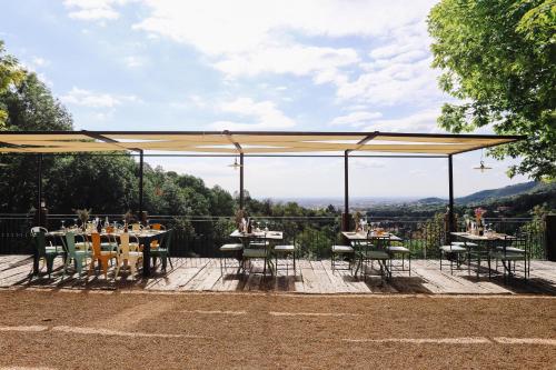 una zona pranzo con tavoli e sedie sotto un baldacchino di AGRITURISMO CA' FENILE ad Alzano Lombardo