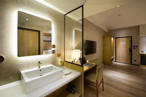 a bathroom with a sink and a desk and a mirror at Joyfultel in Guishan