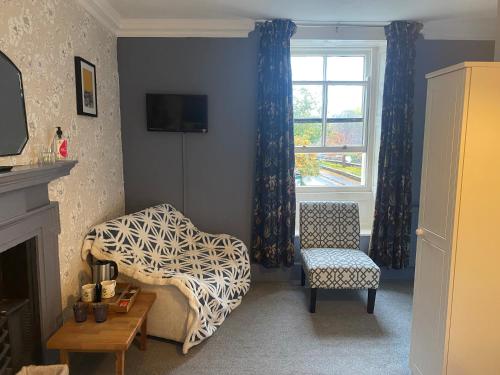 a living room with a chair and a window at Talbot House Bed & Breakfast and Tearoom in Pateley Bridge