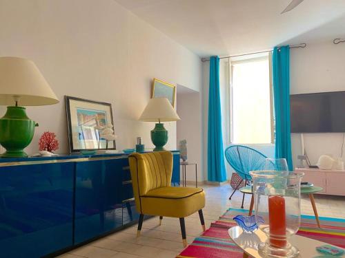 un salon avec une chaise jaune et une table dans l'établissement Spacieux et confortable appartement T3 au centre ville d Ajaccio, à Ajaccio