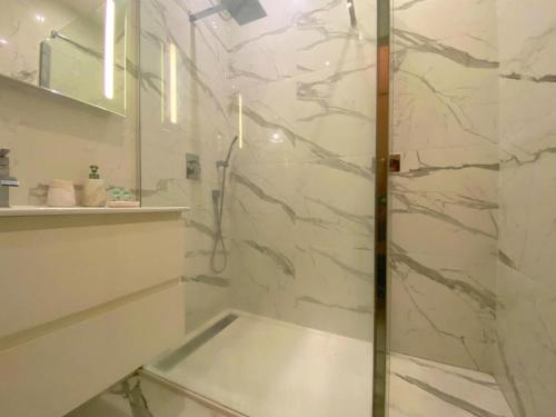a shower with a glass door in a bathroom at Spacieux et confortable appartement T3 au centre ville d Ajaccio in Ajaccio