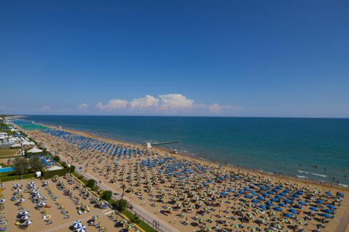 a beach with a lot of umbrellas and the ocean at Termini Beach Hotel & Suites in Lido di Jesolo