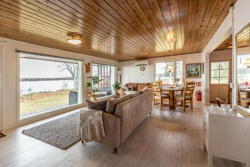 a living room with a couch and a table at Lapland Sunrise Cottage with lakefront Sauna in Rovaniemi