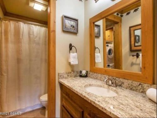 a bathroom with a sink and a toilet and a mirror at Red Pine Mountain Retreat steps from the Cabriolet in Park City