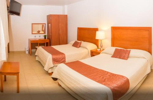 una camera d'albergo con due letti e una televisione di Hotel Marllou a Xalapa