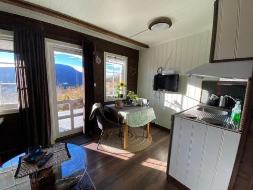 a kitchen with a table and two windows at Private apartments!Oppdal Alpintun, Skisenter-Stølen in Oppdal