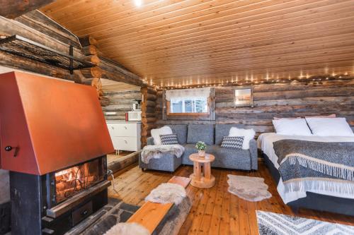 a bedroom with a bed and a fireplace in a log cabin at Lapland Northern Lights Cabin - Wooden Sauna in Rovaniemi