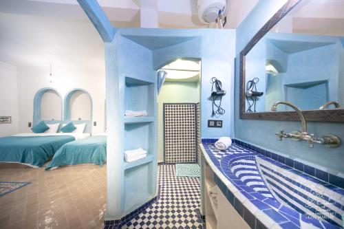 uma casa de banho com uma banheira e um lavatório com um espelho. em L'homme Du Désert A Merzouga em Merzouga
