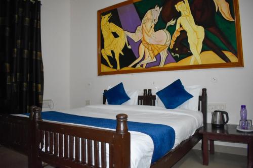 a bedroom with a bed with a painting on the wall at The Ranthambhore Heritage in Sawāi Mādhopur