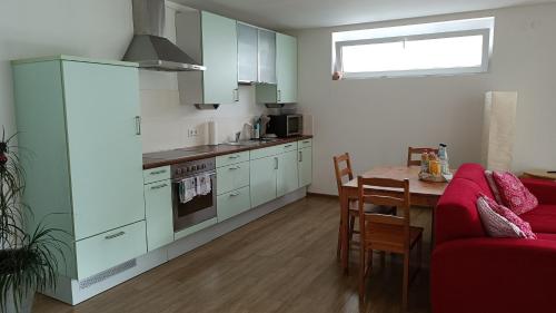 a kitchen with a red couch and a table in a room at Apartment Baumeister in Weilheim an der Teck