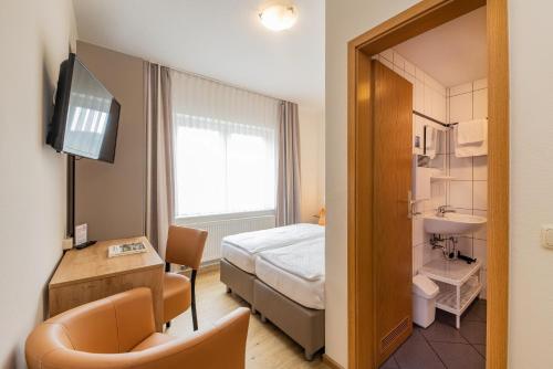 Hotel Bamberger Hof, garni في إيزيناخ: غرفة الفندق بسرير ومغسلة