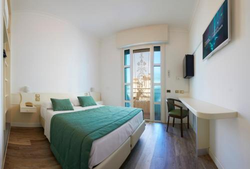 Cette chambre comprend un lit et un bureau. dans l'établissement Ruhl Beach Hotel & Suites, à Lido di Jesolo