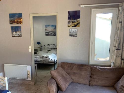 - un salon avec un canapé et une chambre dans l'établissement Maison de pays au centre du village, à Saint-Martin-de-Ré