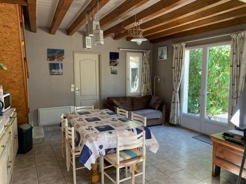 un salon avec une table et un canapé dans l'établissement Maison de pays au centre du village, à Saint-Martin-de-Ré