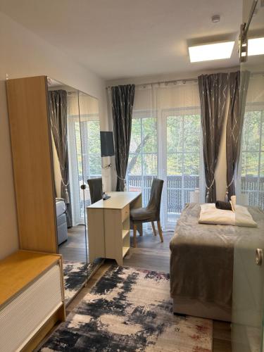 a bedroom with a bed and a desk and window at Hotel Il David in Königsfeld im Schwarzwald