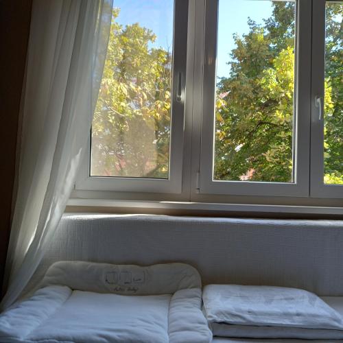a bed in a room with two windows at Rivijera in Belgrade