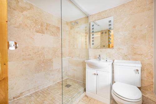 a bathroom with a toilet and a glass shower at No 9 The Hill Cromford Nr Matlock Bath in Cromford