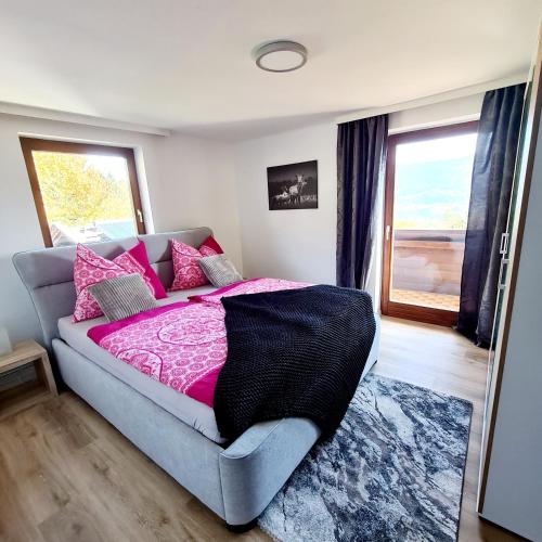 a bedroom with a bed with pink sheets and a window at Ferienwohnung St. Josef in Bodensdorf