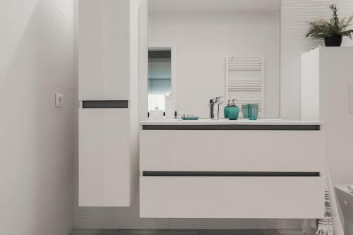 a kitchen with white cabinets and a sink at Ambassador Apartment in Baia Mare