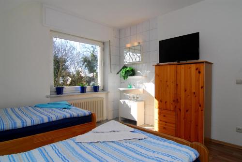 een slaapkamer met een bed en een televisie op een kast bij Ferienwohnung + Monteurwohnungen Krings in Eschweiler