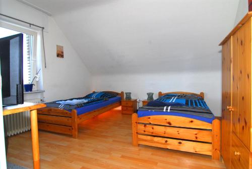 a bedroom with two beds and a television in it at Monteurzimmer Krings Baptistastr 2a in Eschweiler
