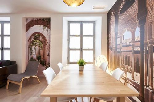comedor con mesa de madera y sillas blancas en Apartamento ideal para familias en Granada, en Granada