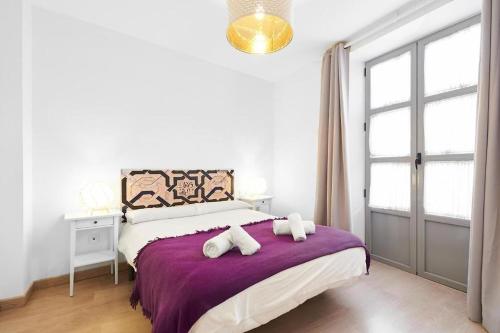1 dormitorio con 1 cama grande con manta morada en Apartamento ideal para familias en Granada, en Granada