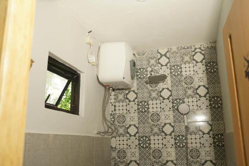 a bathroom with a toilet and a window at Happy House BnB Bromo backpacker in Probolinggo