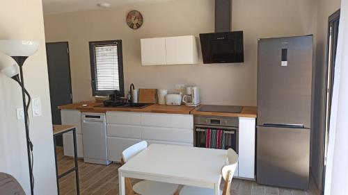 Il comprend une cuisine équipée d'une table blanche et d'un réfrigérateur. dans l'établissement Maison d'hôtes calme proche village, à Bédoin