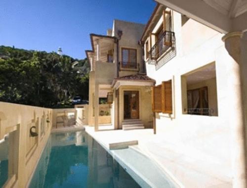 a house with a swimming pool in front of a house at Victoria's At Wategos in Byron Bay