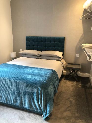1 dormitorio con 1 cama grande y cabecero azul en Unique one bed contemporary bungalow town centre en March