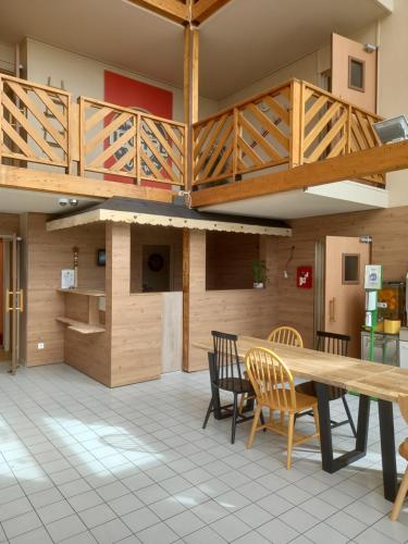 a dining room with a wooden table and chairs at Green Hôtels Orléans Nord-Saran in Saran