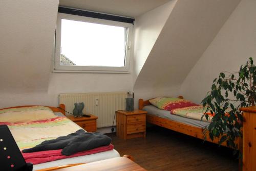 a attic bedroom with two beds and a window at Monteurzimmer Krings Baptistastr 2a in Eschweiler