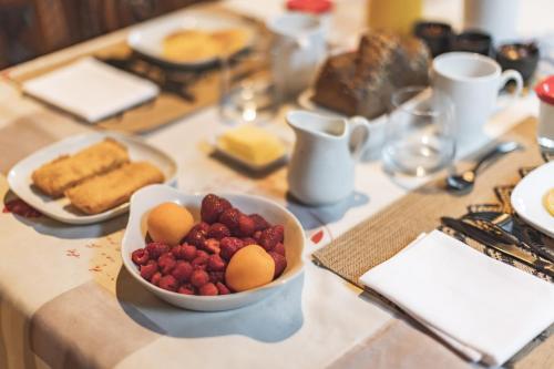 a table topped with a bowl of strawberries and bread at Chalet Ouréa in Campan