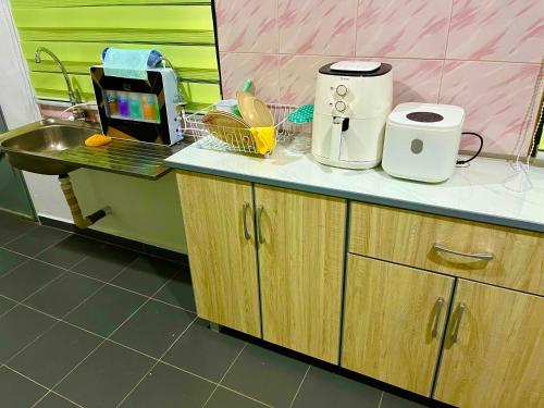 - une cuisine avec un évier et un comptoir dans l'établissement D'YELLOW HOMESTAY KANGAR PERLIS, à Kangar