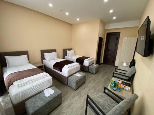 a hotel room with two beds and a television at Shosh Palace in Tashkent