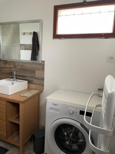 a laundry room with a washing machine and a sink at La maison sur la plage in Marennes
