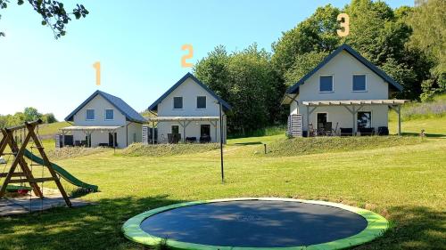 a playground with houses and a trampoline at Sikory Hill in Czaplinek