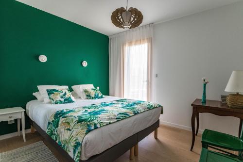 a green bedroom with a bed and a window at La Grande Croix Bienvenue in Saint-Cast-le-Guildo