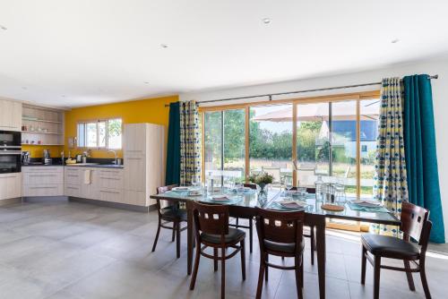 une salle à manger avec une table et des chaises et une cuisine dans l'établissement La Petite Croix Bienvenue, à Saint-Cast-le-Guildo