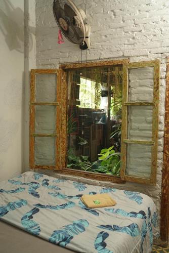 a bed in a room with a window at Happy House BnB Bromo backpacker in Probolinggo