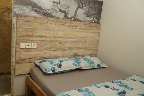 a bed with two pillows on top of it at Happy House BnB Bromo backpacker in Probolinggo