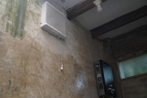 a room with a air conditioner hanging from a wall at Happy House BnB Bromo backpacker in Probolinggo