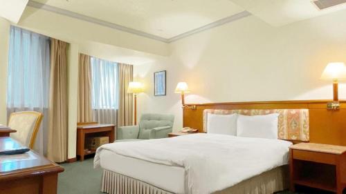 a hotel room with a large bed and a desk at Hotel Avenue in Hsinchu City