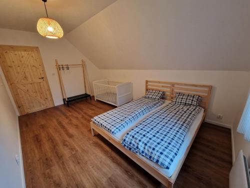 - une chambre avec un lit et du parquet dans l'établissement Cenderowa Ostoja, à Gryźliny