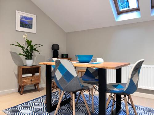 a dining room with a table and four chairs at River Vista Retreat - Luxury duplex Apt - Views - Parking - Cycle storage - Spa access option in Backbarrow