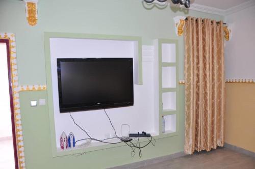 uma televisão de ecrã plano numa parede num quarto em Appartements meublés haut Standing em Bertoua