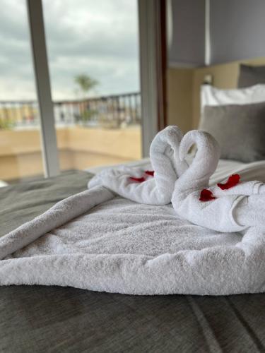 two towels in the shape of swans on a bed at Candia Hotel in Chania
