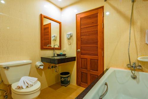a bathroom with a toilet and a tub and a sink at Patong Heaven in Patong Beach