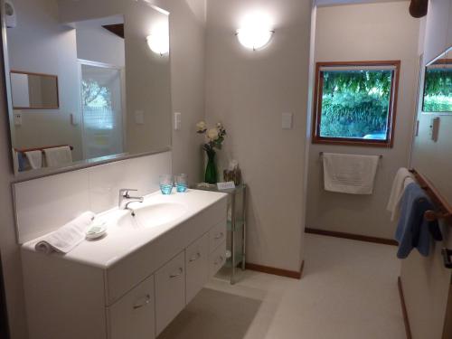 y baño con lavabo blanco y espejo. en Thorold Country House en Thames